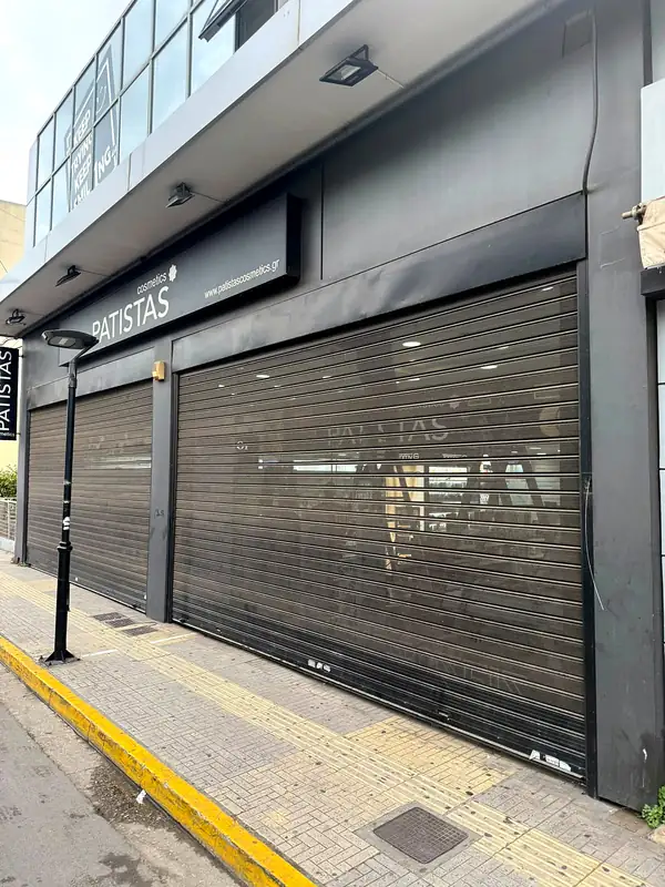 Διάτρητο ρολό ασφαλείας σε κατάστημα με σκούρα πρόσοψη