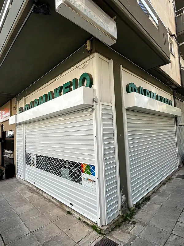 Λευκά ρολά με δικτυωτό σε γωνιακό φαρμακείο